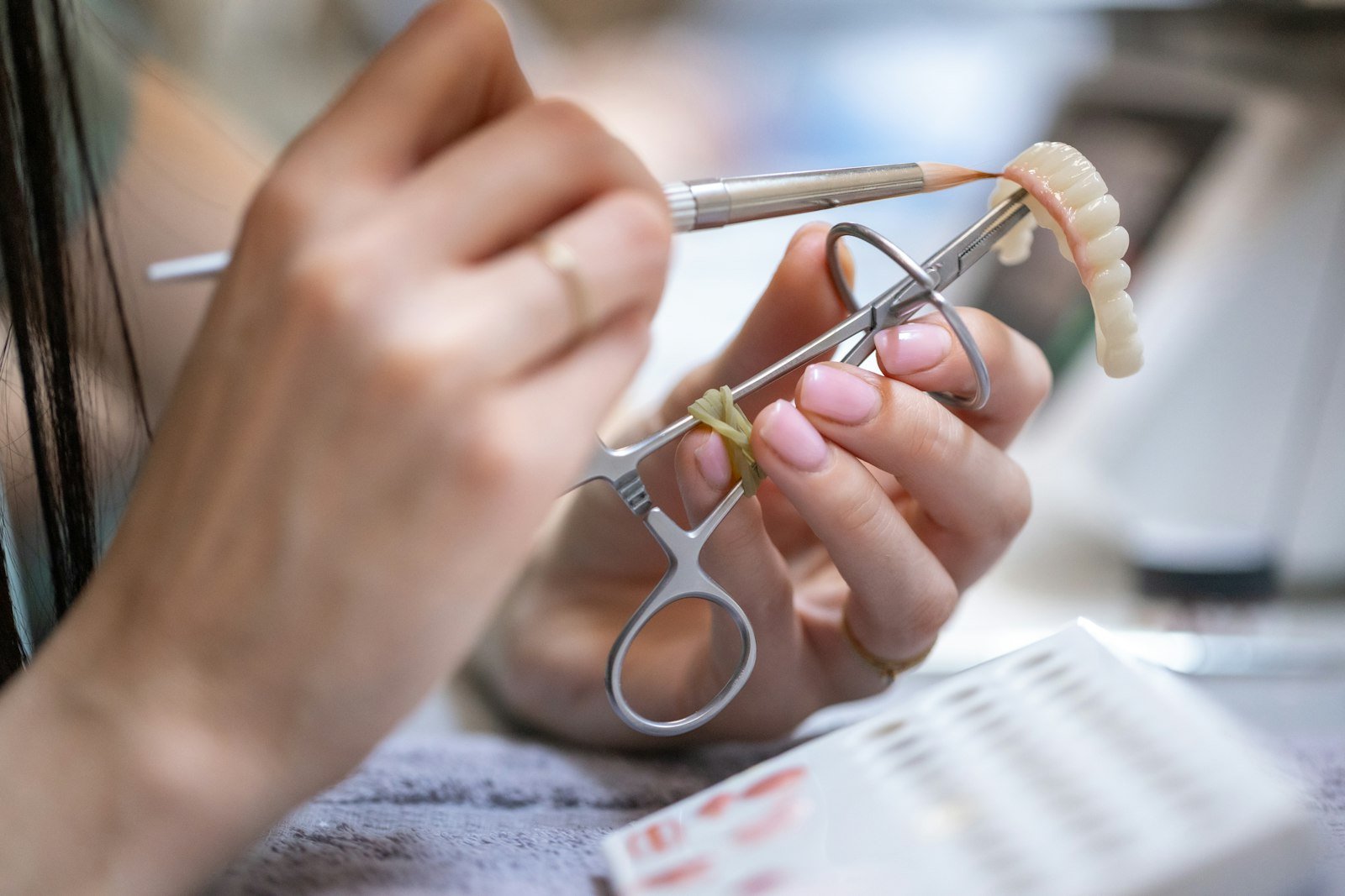 Manos dando forma a una prótesis dental completa